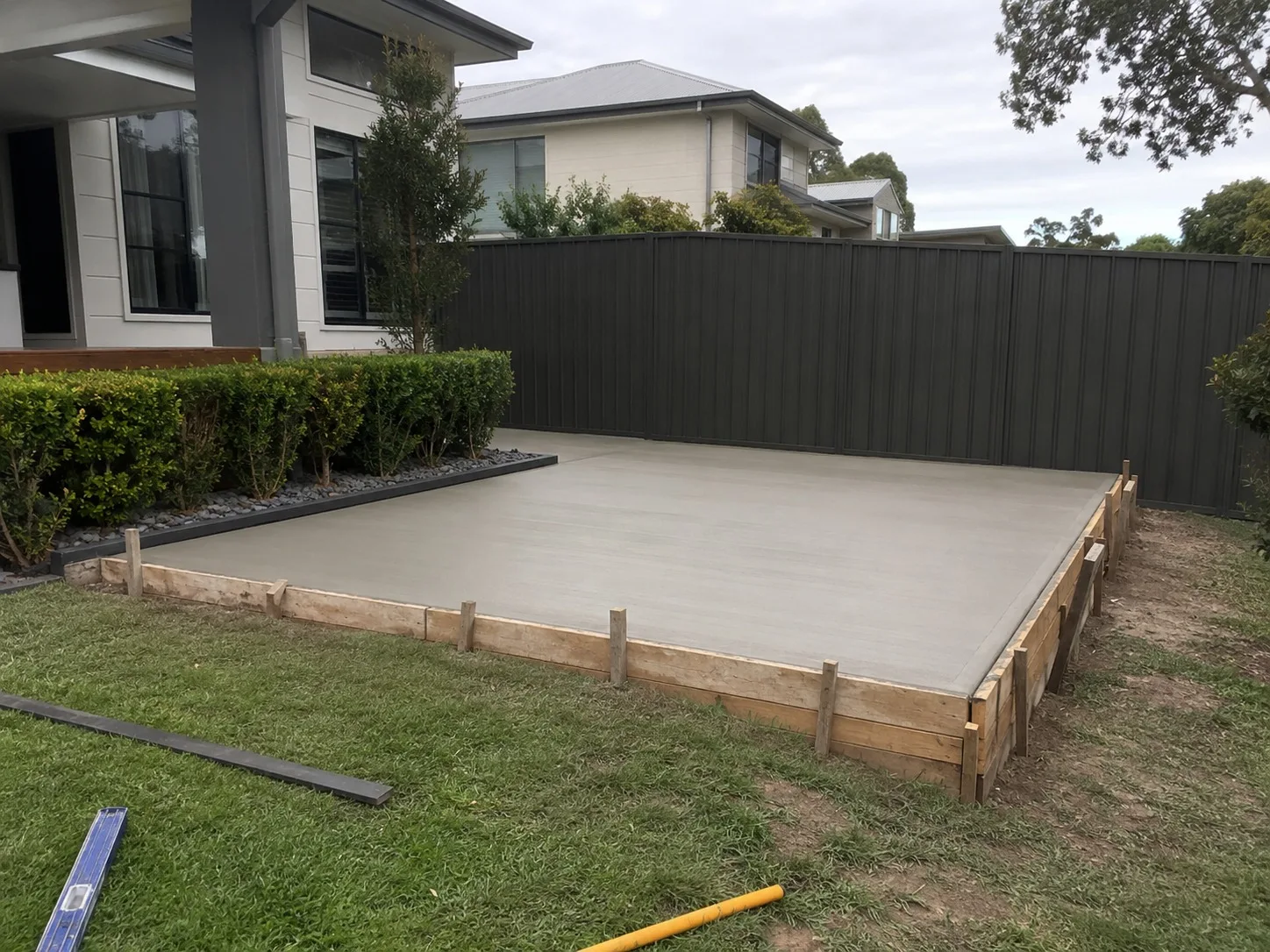 Formed-up and poured shed slab set out on a level lawn behind a Newcastle home