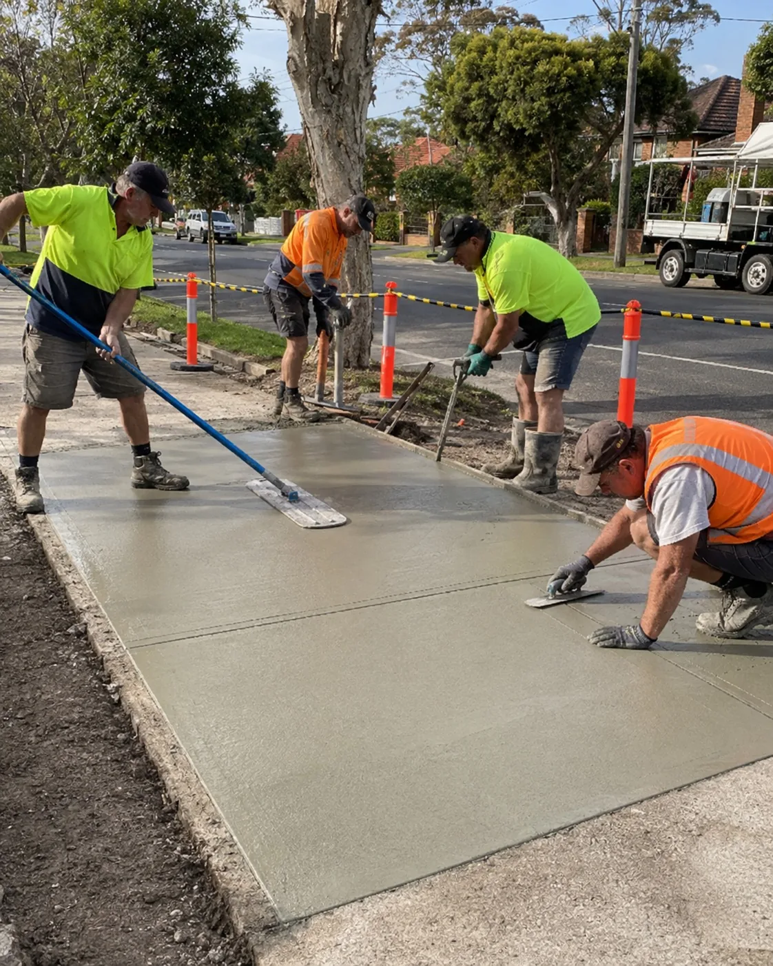 Crew screeding a replacement concrete driveway on a Newcastle street